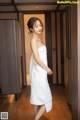 A woman in a white towel standing in a room.