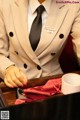 A woman in a suit and tie holding a cup of coffee.