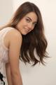 A woman with long brown hair posing for a picture.