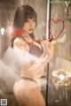 A woman in a black lingerie holding a red heart.