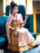 A woman in a kimono sitting on a blue couch.