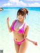 A woman in a pink bikini standing in the ocean.